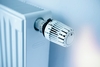 Weißer Flachheizkörper mit Thermostat an der Wand in einer Wohnung.