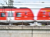 Ein unscharfes Bild einer fahrenden roten Regionalbahn in Nahaufnahme.