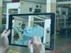 Auf einem Tablet ist ein digitaler Zwilling in einer Fabrik zu sehen