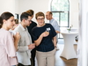 Drei Personen schauen auf ein Flipchart