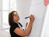 Person schreibt auf einem Flipchart