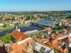 Ein Fluss fließt durch eine Stadt, zwei Brücken führen über den Fluss